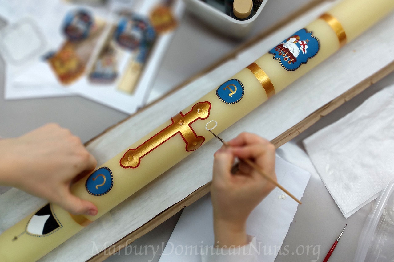 Photo of Dominican nun's hands painting paschal candle.